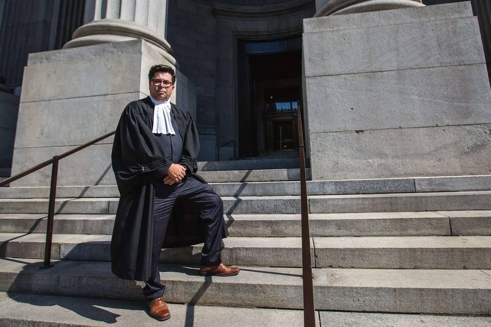 Me Jean-François Boudreau en toge, debout sur les marches d'un palais de justice